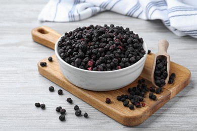 Photo of Bowl and scoop with dried blueberries on white wooden table