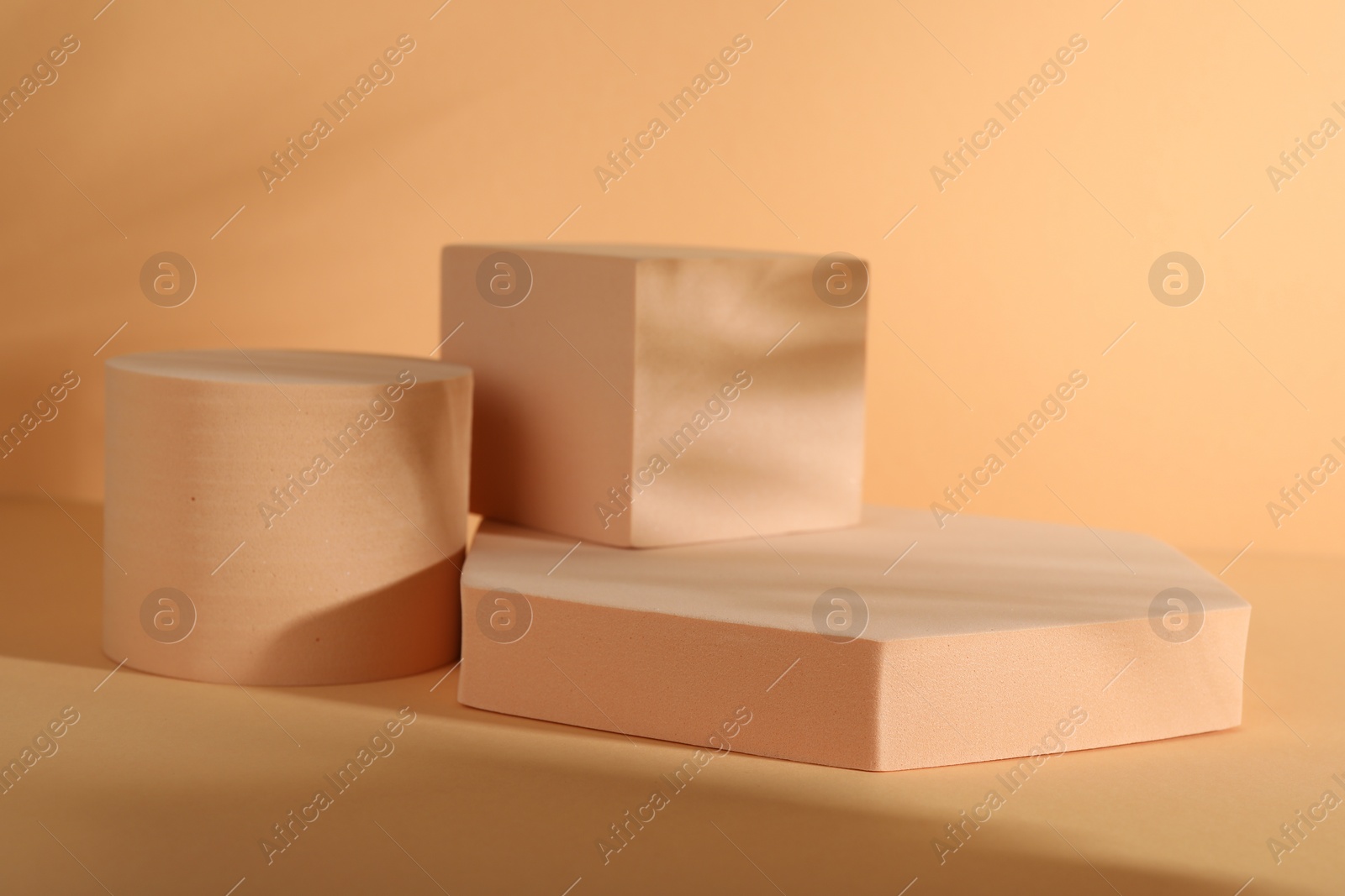 Photo of Presentation of product. Podiums and shadows on orange background. Space for text