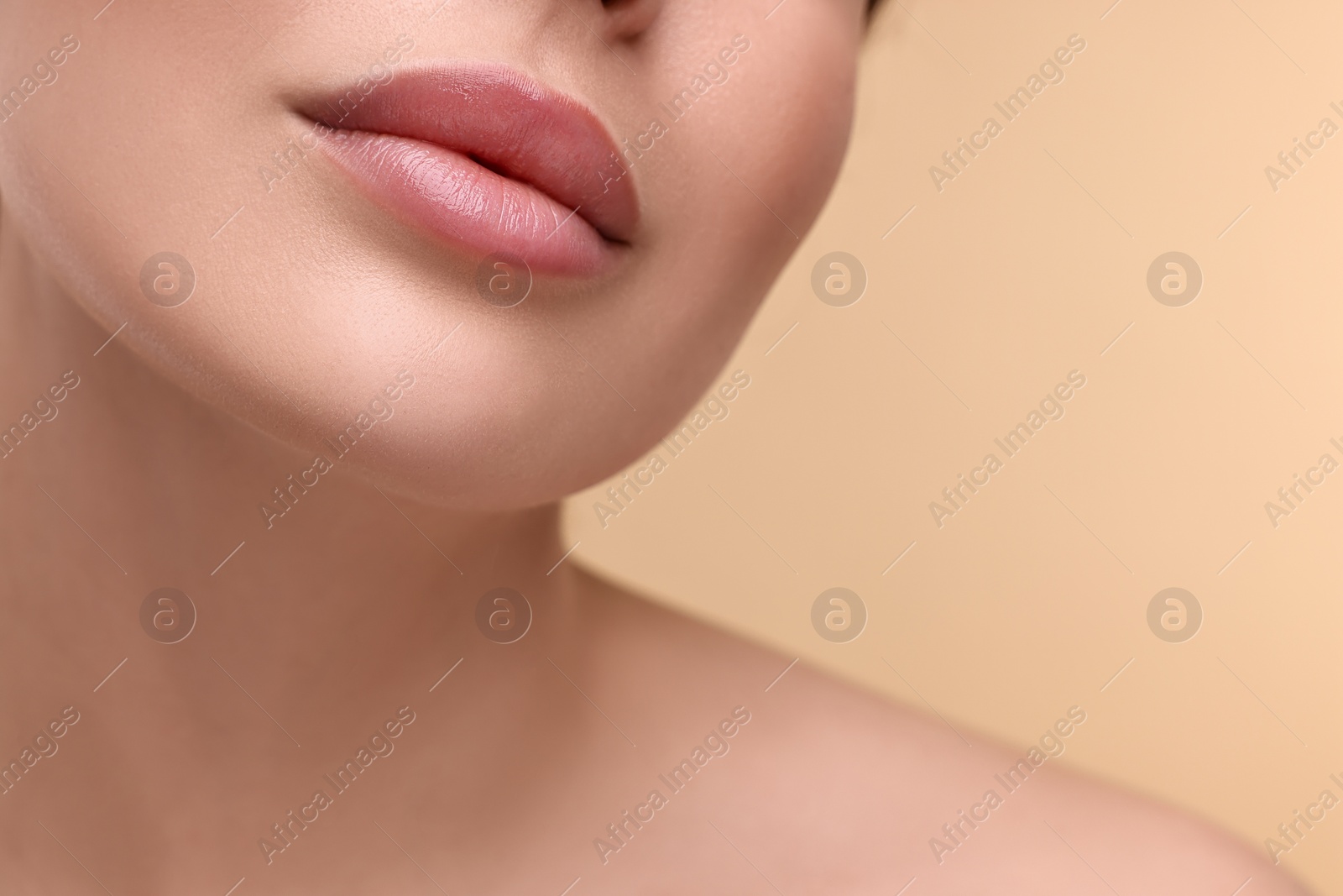 Photo of Woman with beautiful lips on beige background, closeup. Space for text