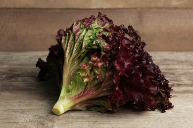 Photo of Fresh red coral lettuce on wooden table