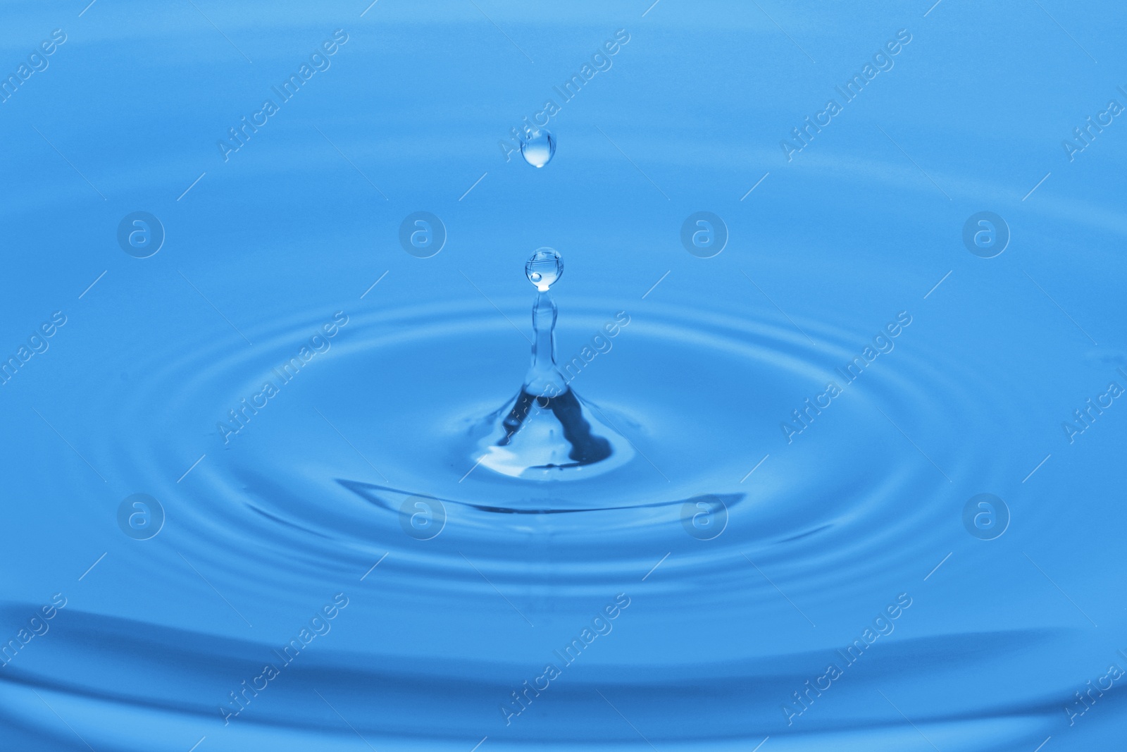 Photo of Splash of blue water with drop, closeup