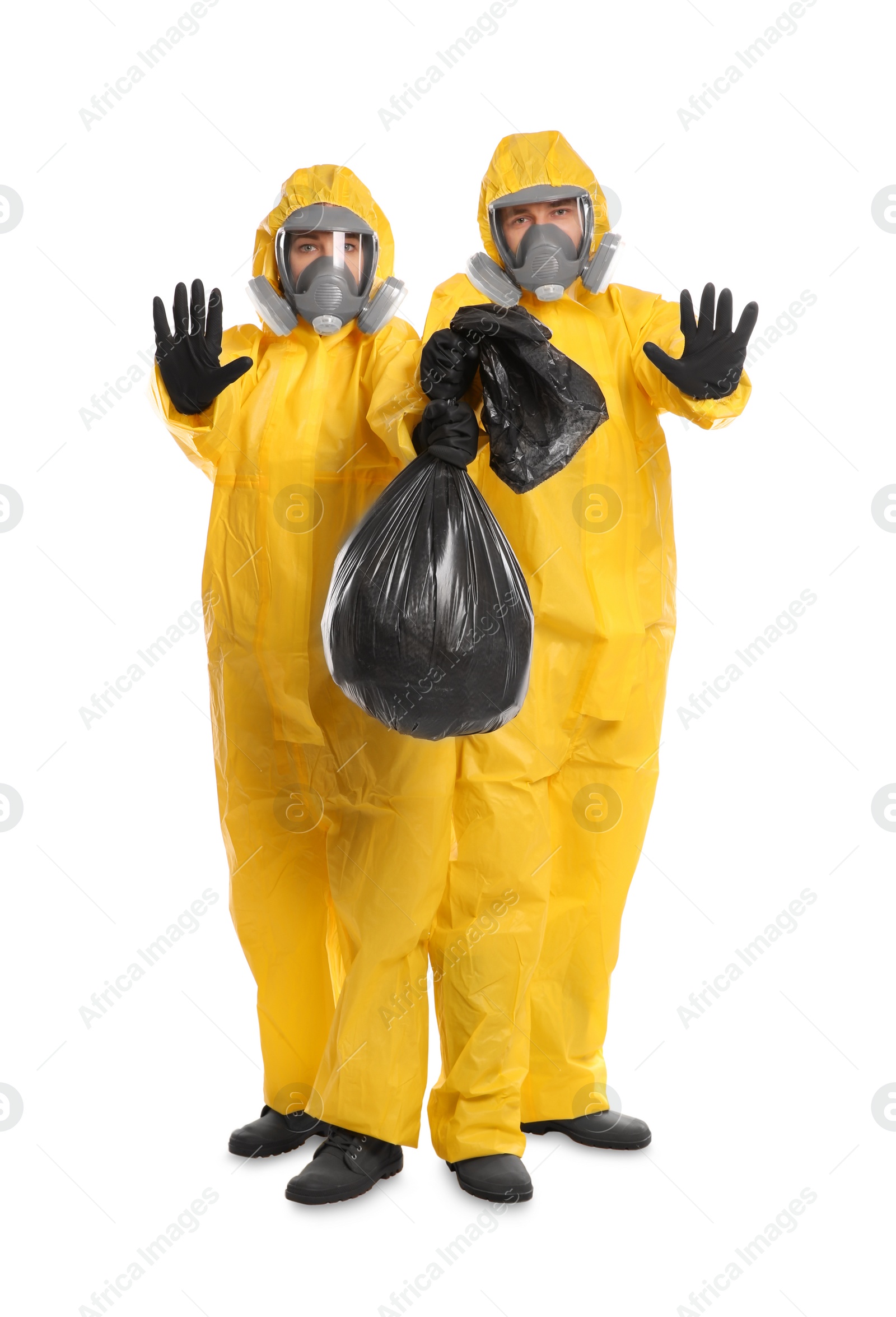 Photo of Man and woman in chemical protective suits with trash bag on white background. Virus research