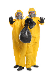 Photo of Man and woman in chemical protective suits with trash bag on white background. Virus research