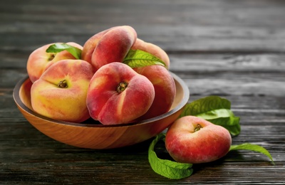 Fresh ripe donut peaches on black wooden table