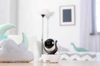 Photo of Baby monitor and toys on table in room. CCTV equipment