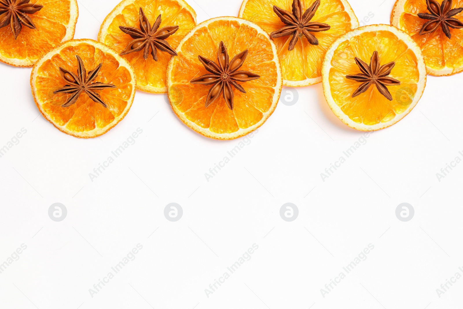 Photo of Dry orange slices and anise stars on white background, flat lay. Space for text