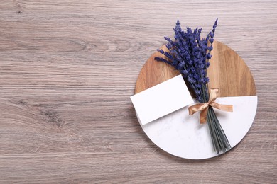 Photo of Bouquet of beautiful preserved lavender flowers, blank card and board on wooden table, top view. Space for text