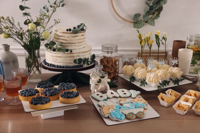 Beautiful cake and other treats on table in room. Baby shower party