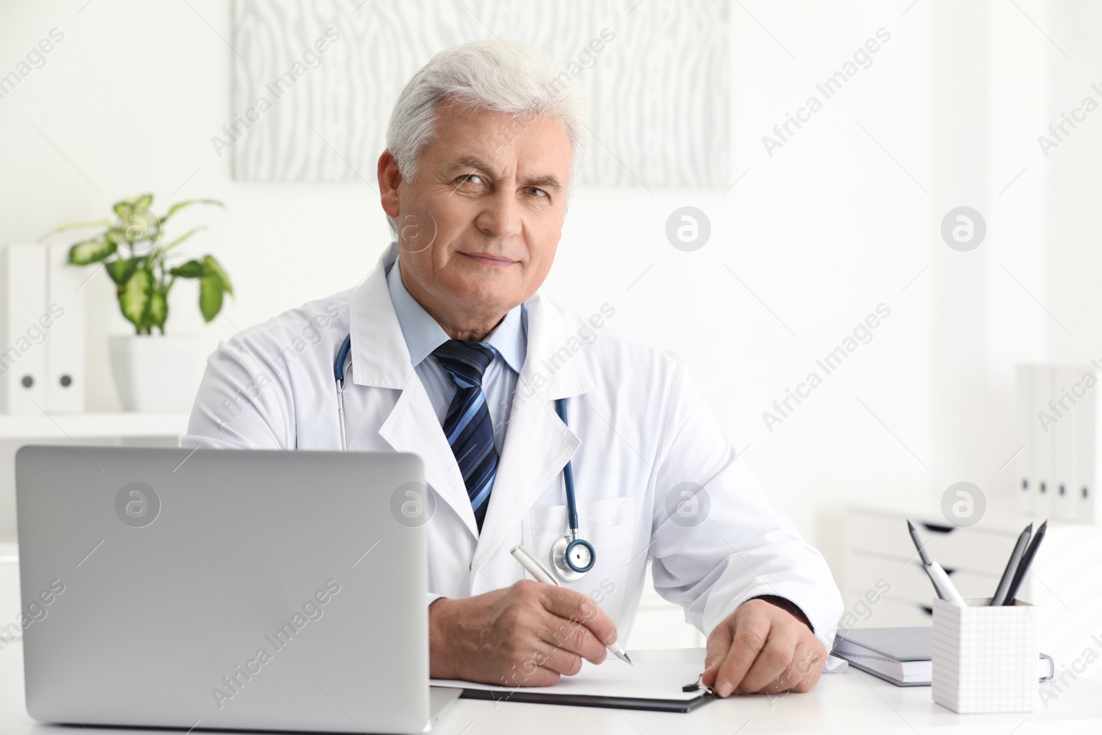 Photo of Portrait of senior doctor in white coat at workplace