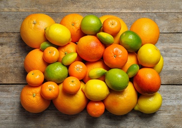 Flat lay composition with different citrus fruits on wooden background