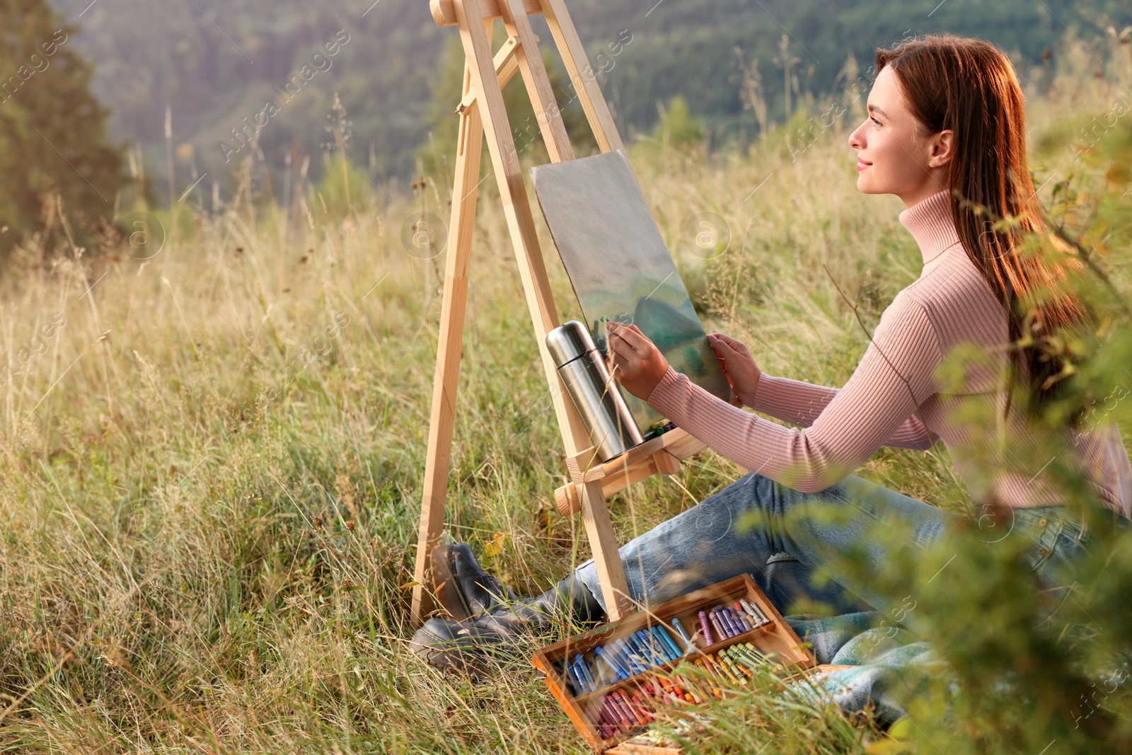 Photo of Young woman drawing landscape with soft pastels in nature. Space for text