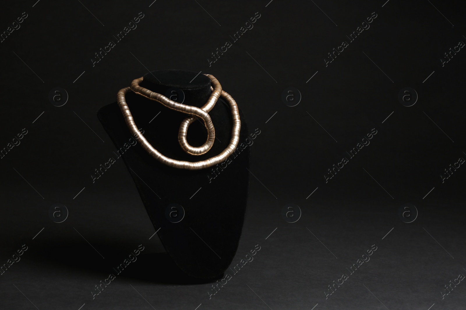 Photo of Stylish jewelry on stand against black background, space for text