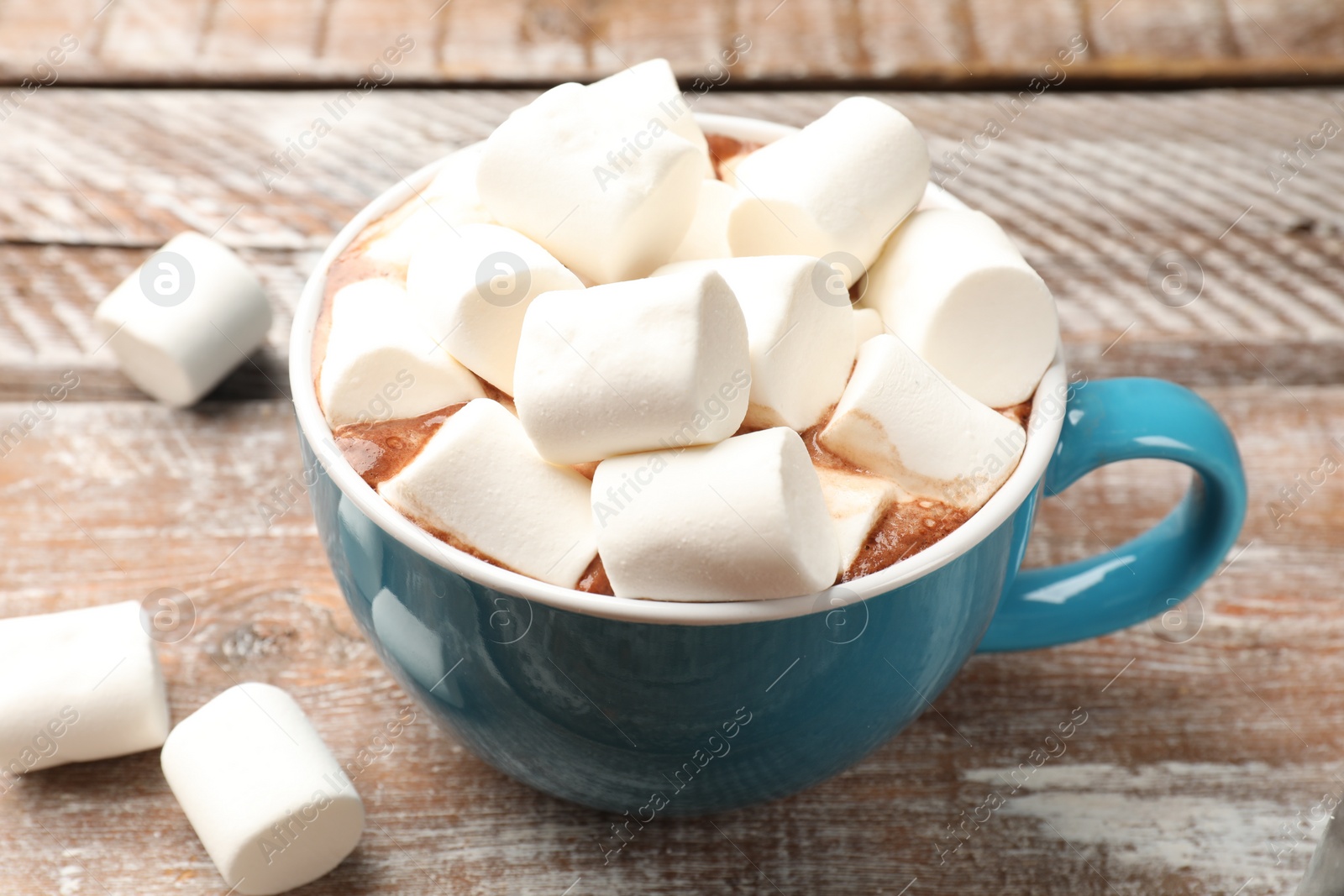 Photo of Tasty hot chocolate with marshmallows on wooden table, closeup