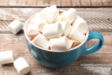 Tasty hot chocolate with marshmallows on wooden table, closeup