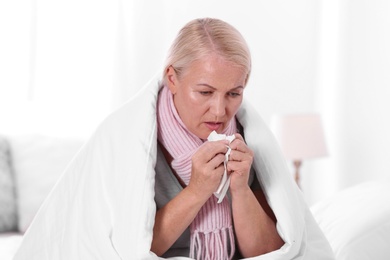 Photo of Ill mature woman suffering from cough at home