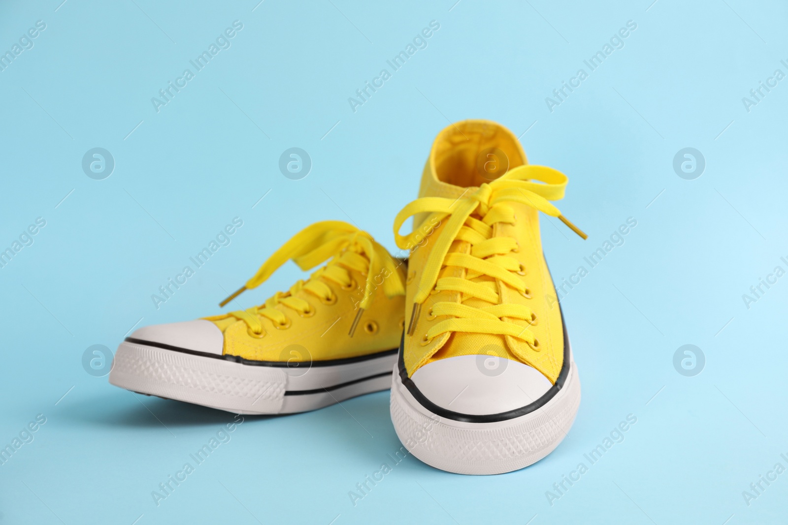 Photo of Pair of stylish sneakers on light blue background