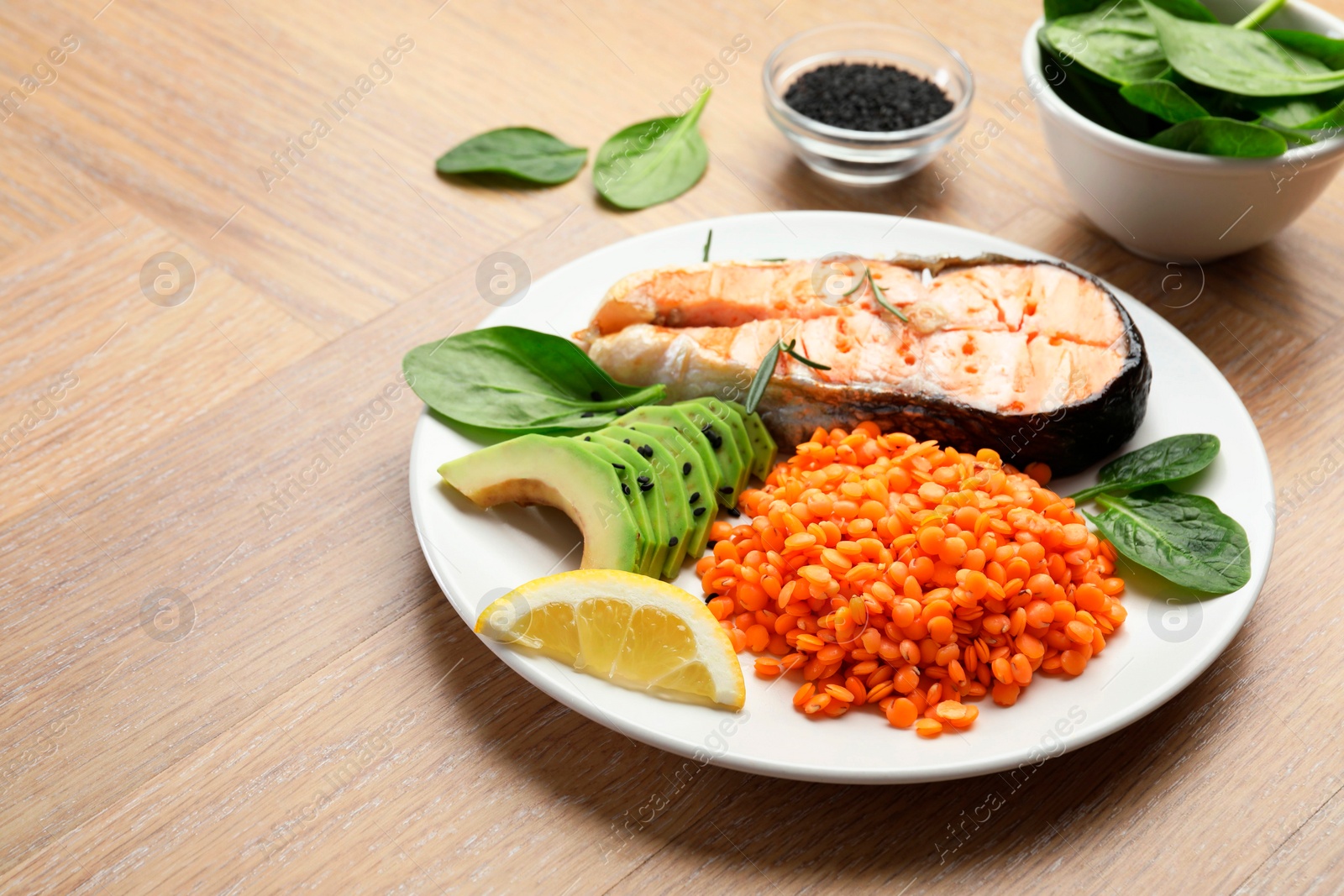 Photo of Plate with healthy food high in vegetable fats on wooden table, closeup. Space for text