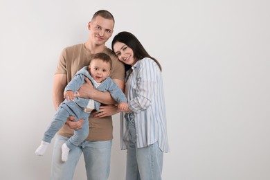 Portrait of happy family with little child on light background. Space for text