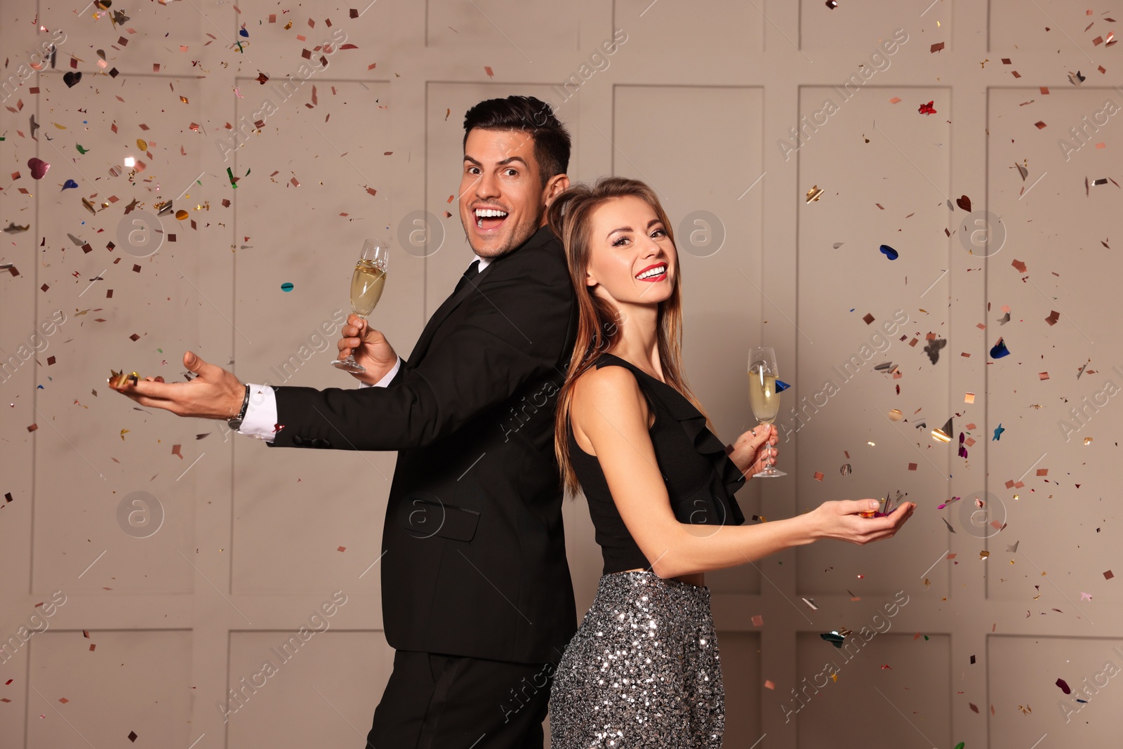 Photo of Happy couple with glasses of sparkling wine celebrating New Year indoors