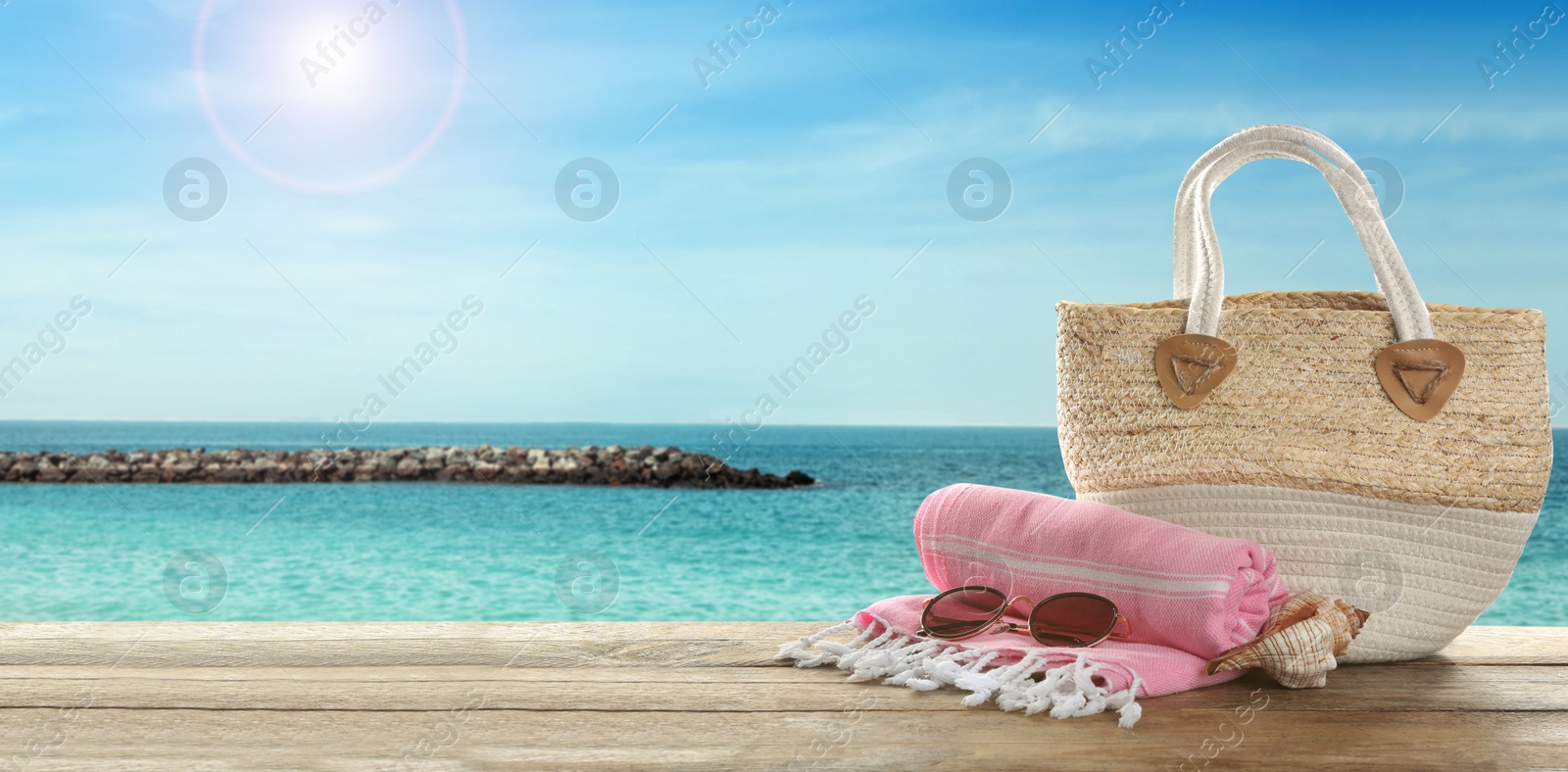Image of Beach accessories on wooden surface near ocean, space for text. Banner design 