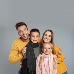 Photo of Happy family in warm clothes on grey background. Winter season