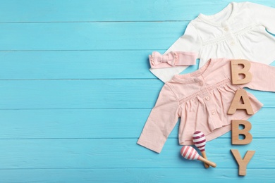 Photo of Flat lay composition with clothes and space for text on wooden background. Baby accessories