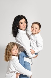 Little children with their mother on white background