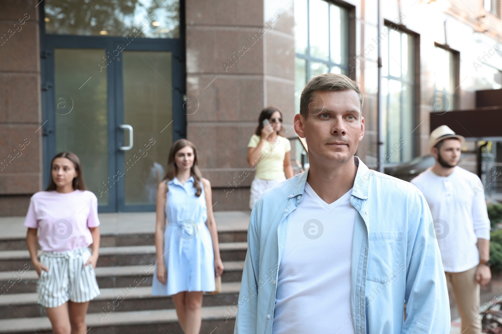 Photo of Handsome man walking on modern city street