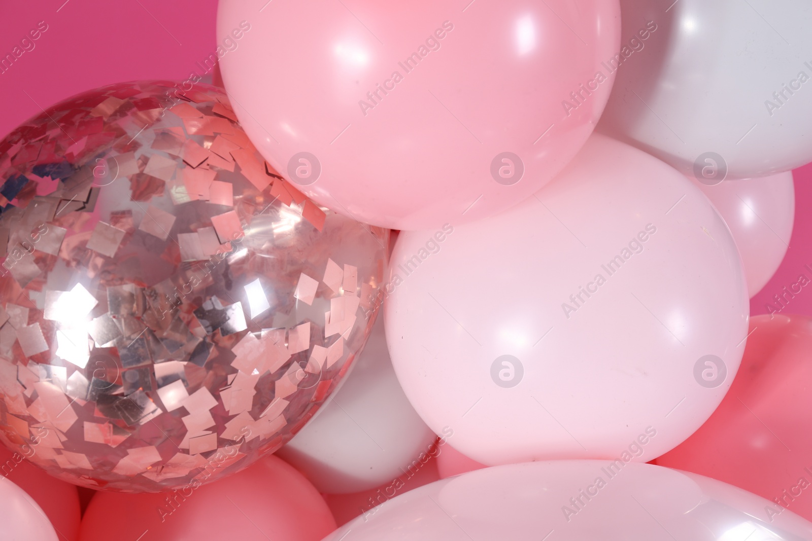 Photo of Beautiful colorful balloons on pink background, closeup