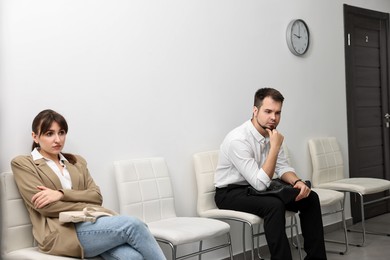 Photo of Man and woman waiting for job interview indoors