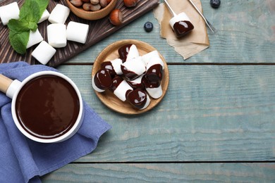 Photo of Delicious marshmallows covered with chocolate on wooden table, flat lay. Space for text