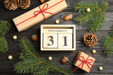 Photo of Flat lay composition with block calendar on black wooden table