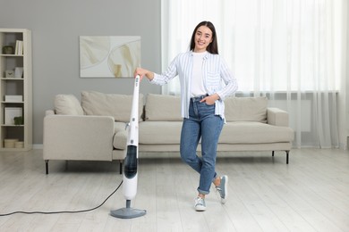 Happy woman with steam mop at home