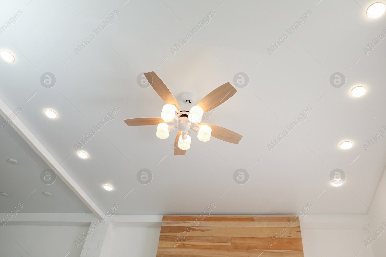 Photo of Modern ceiling fan with lamps indoors. Interior element