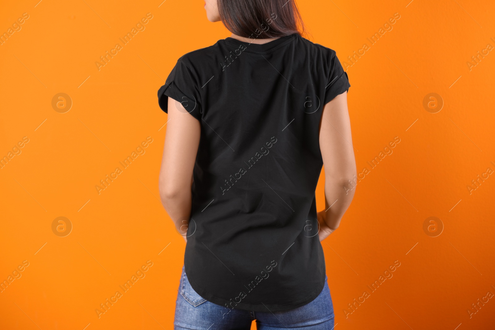Photo of Young woman in black t-shirt on color background. Mockup for design