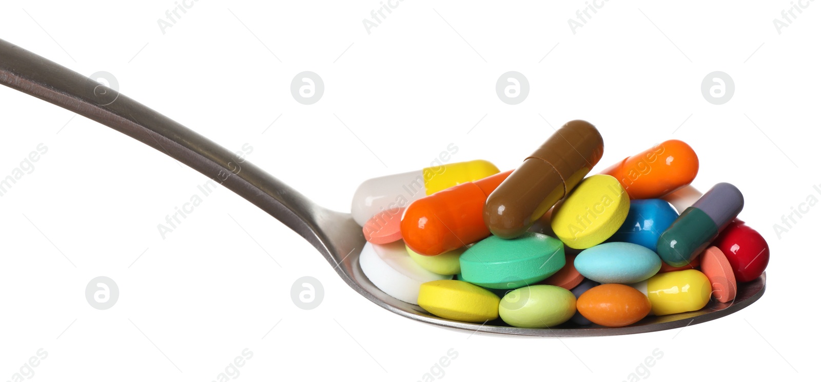 Photo of Different colorful pills in spoon isolated on white