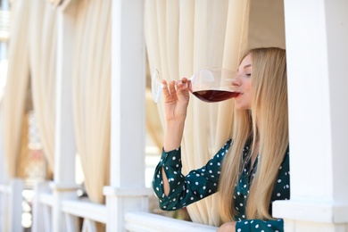 Photo of Beautiful woman drinking wine on restaurant terrace