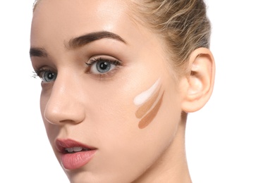 Photo of Young woman with different shades of skin foundation on her face against white background. Professional makeup