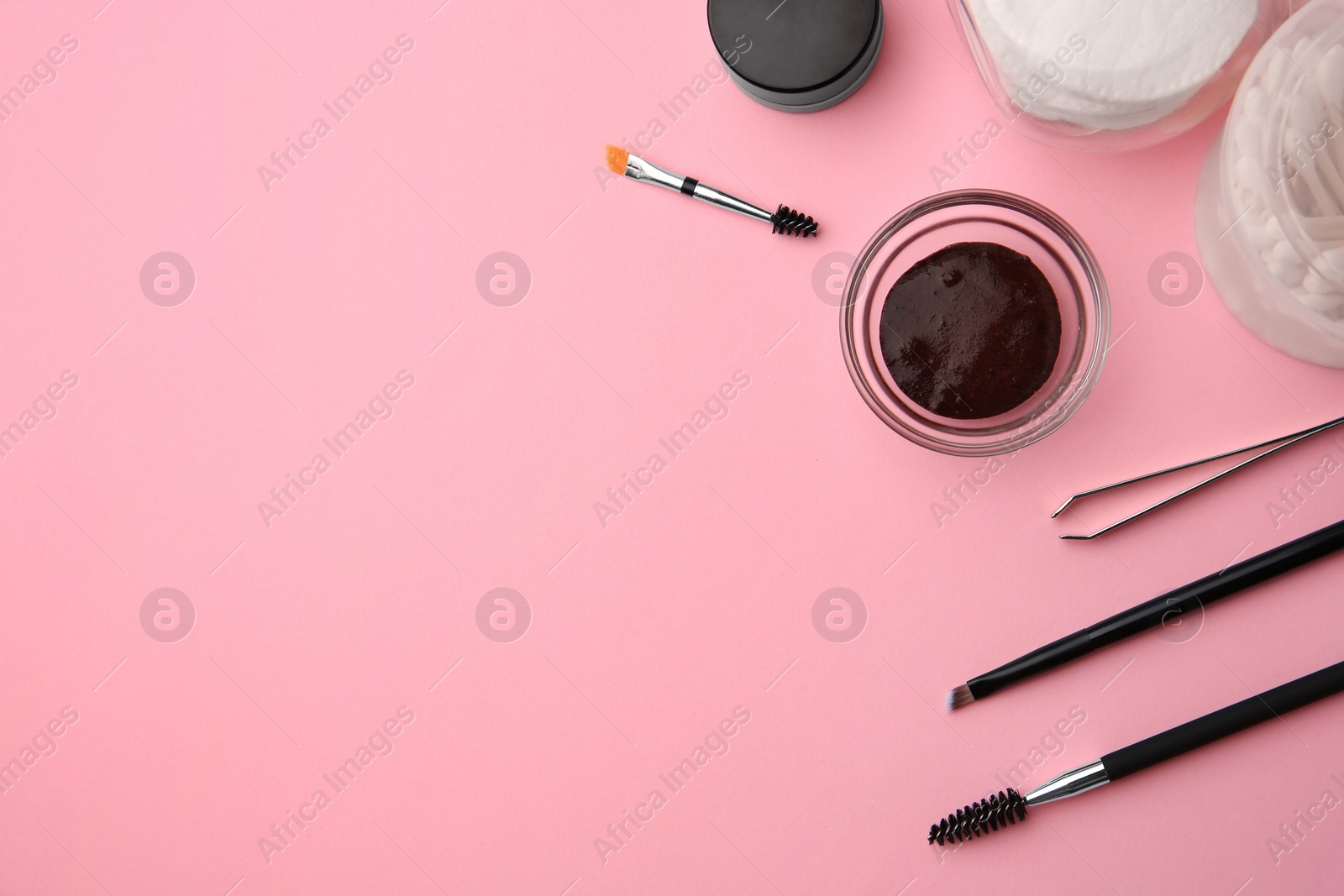 Photo of Flat lay composition with eyebrow henna and professional tools on pink background, space for text