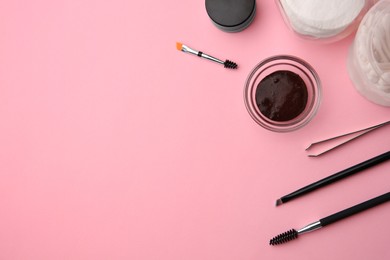 Photo of Flat lay composition with eyebrow henna and professional tools on pink background, space for text