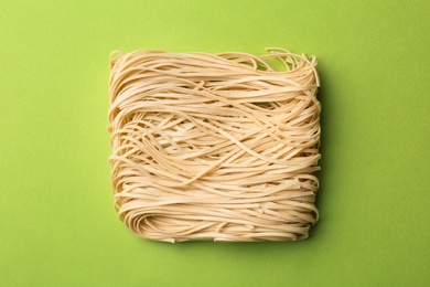 Photo of Block of quick cooking noodles on color background, top view