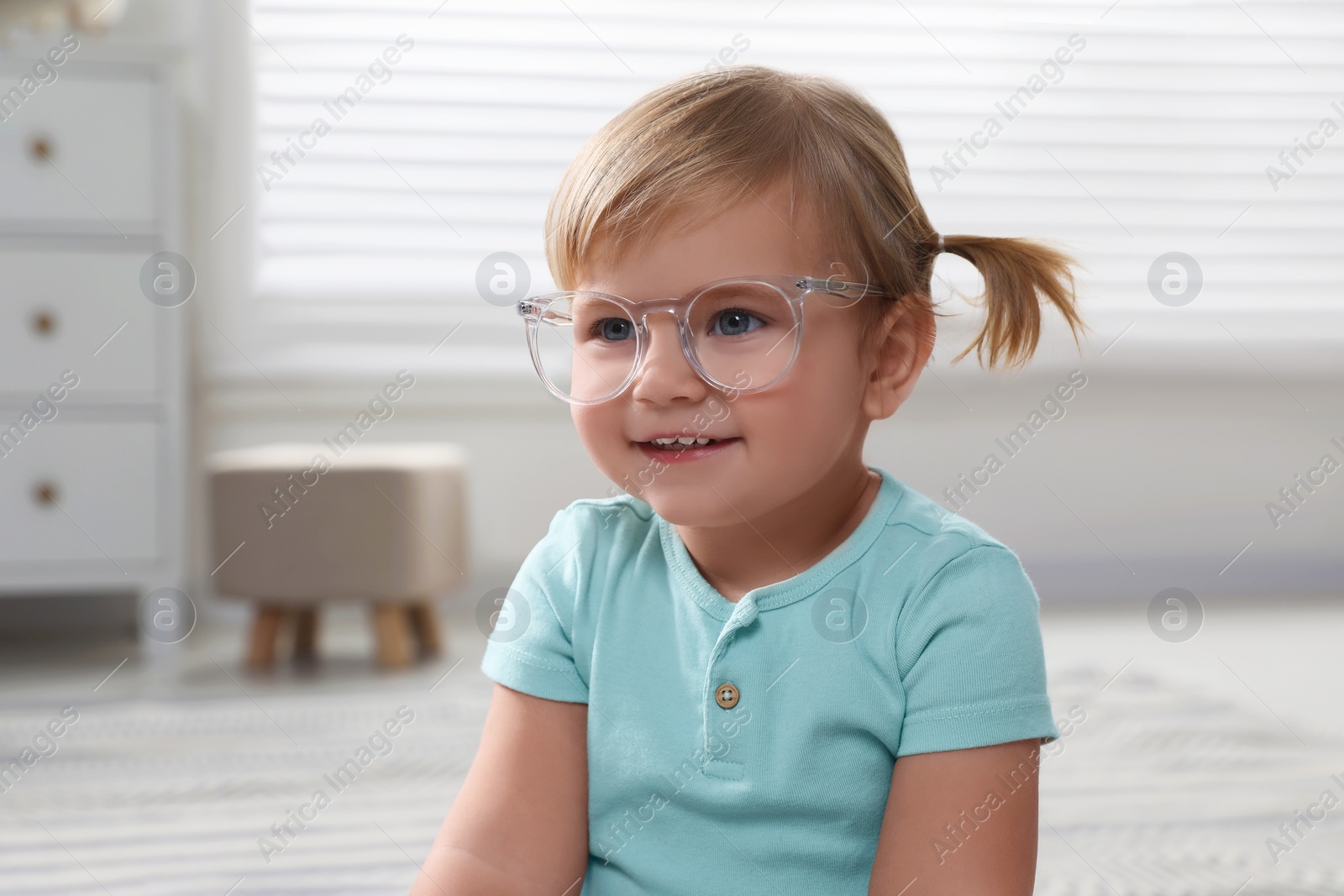 Photo of Cute little girl in glasses at home. Space for text