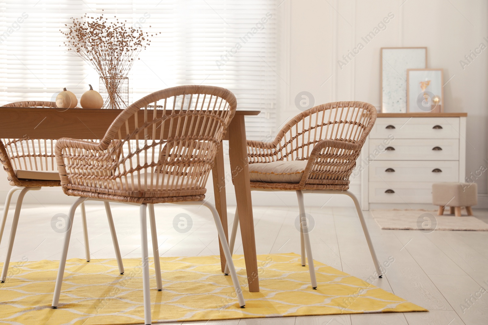 Photo of Dining room interior with wooden table and wicker chairs