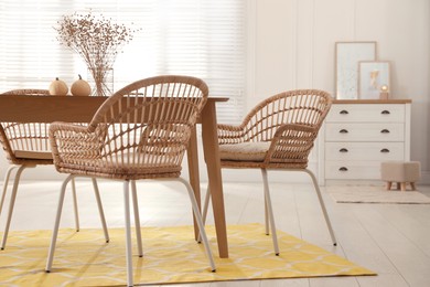 Dining room interior with wooden table and wicker chairs