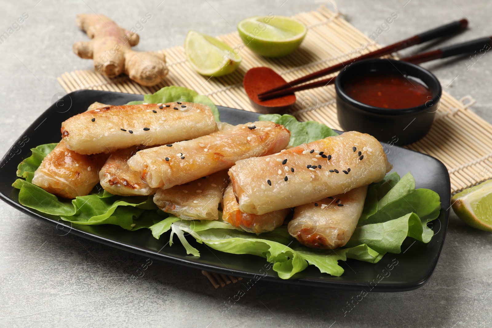 Photo of Tasty fried spring rolls served on gray table, closeup