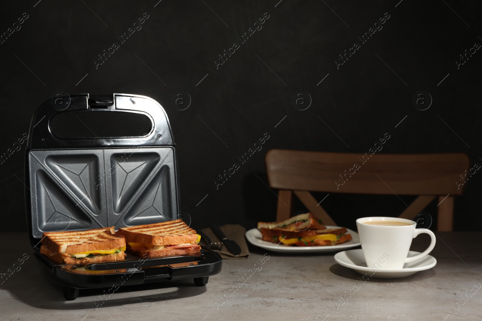 Photo of Modern grill maker with tasty sandwiches and cup of coffee on light grey table