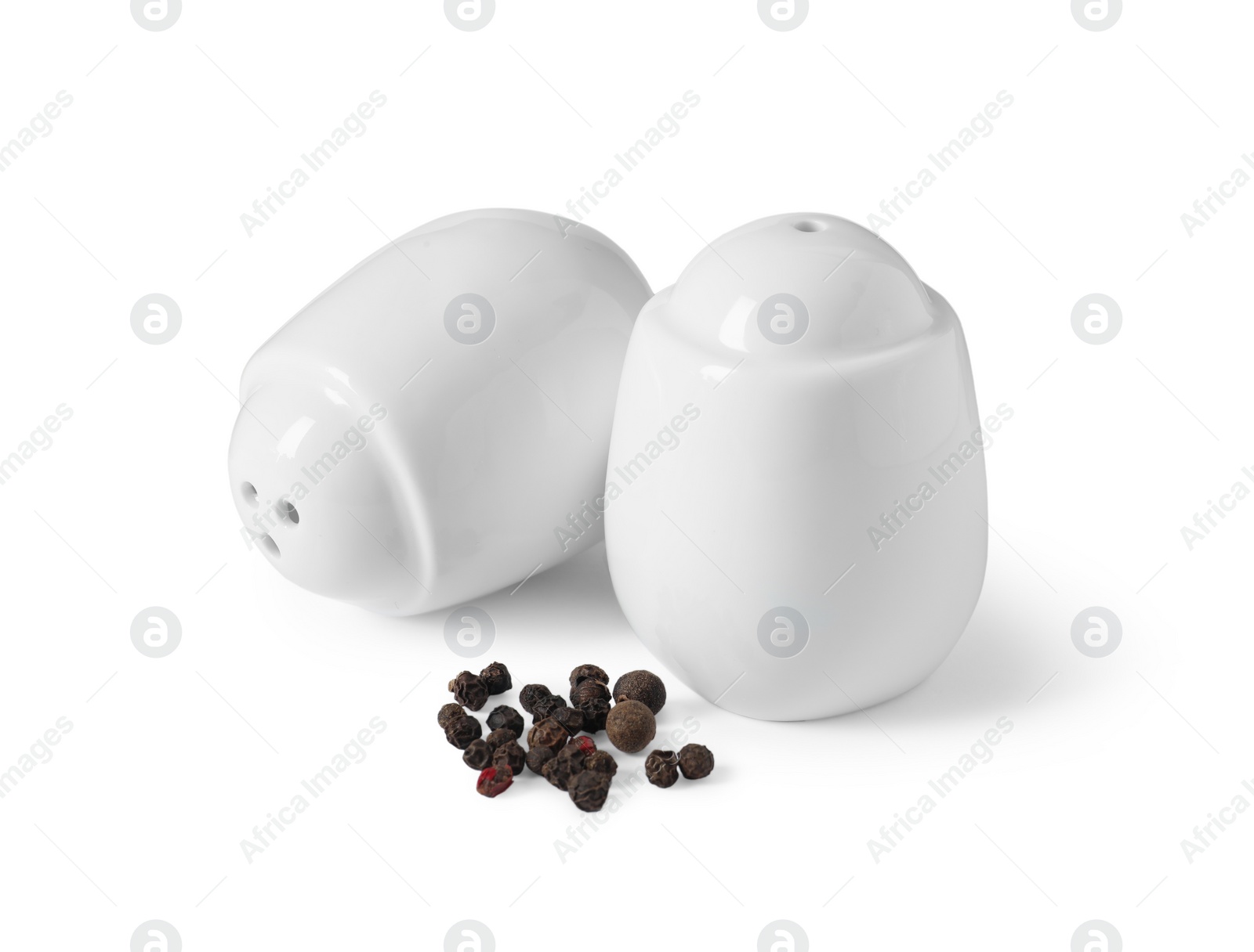 Photo of Salt and pepper shakers with grains isolated on white