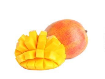 Delicious whole and cut mangoes on white background