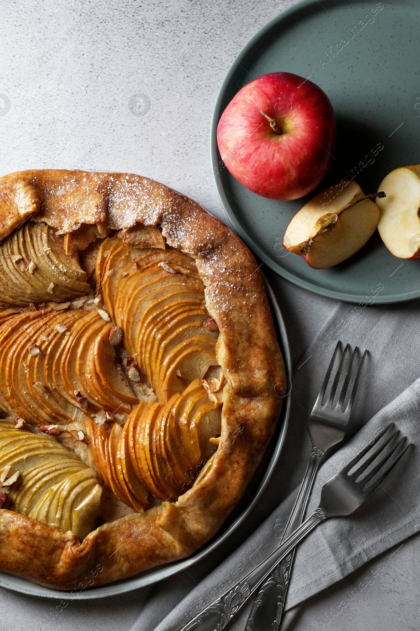 Photo of Delicious galette with apples served on light grey textured table, flat lay