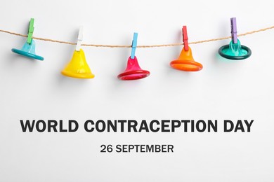 Image of World contraception day. Colorful condoms hanging on clothesline on white background